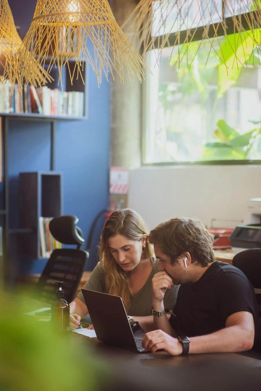 brands business and corporate photography -12 | Pacific Photography Two coworkers review notes together at a laptop in a bright, modern office.