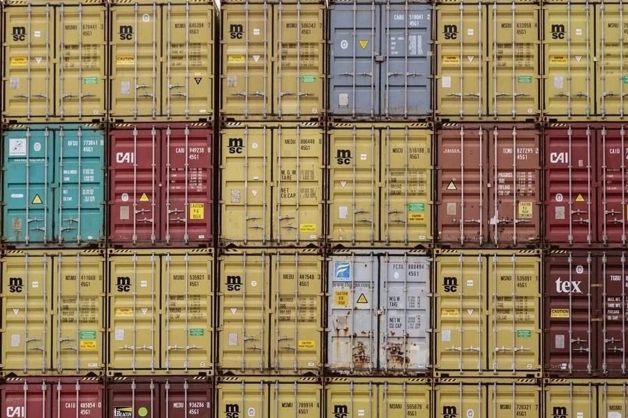 brands business and corporate photography -29 | Pacific Photography Stacks of shipping containers in yellow, teal, red and brown arranged in a grid of cargo units.