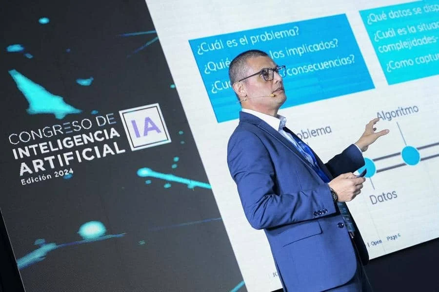 brands business and corporate photography -32 | Pacific Photography Speaker in a blue suit presenting at an AI conference stage (Congreso de Inteligencia Artificial, Edición 2024).