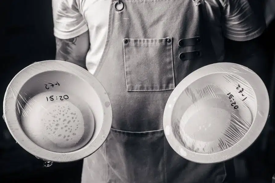 food menu and restaurant photography costa rica -3 | Pacific Photography Chef in an apron holding two shallow bowls wrapped in plastic, each labeled 15:20