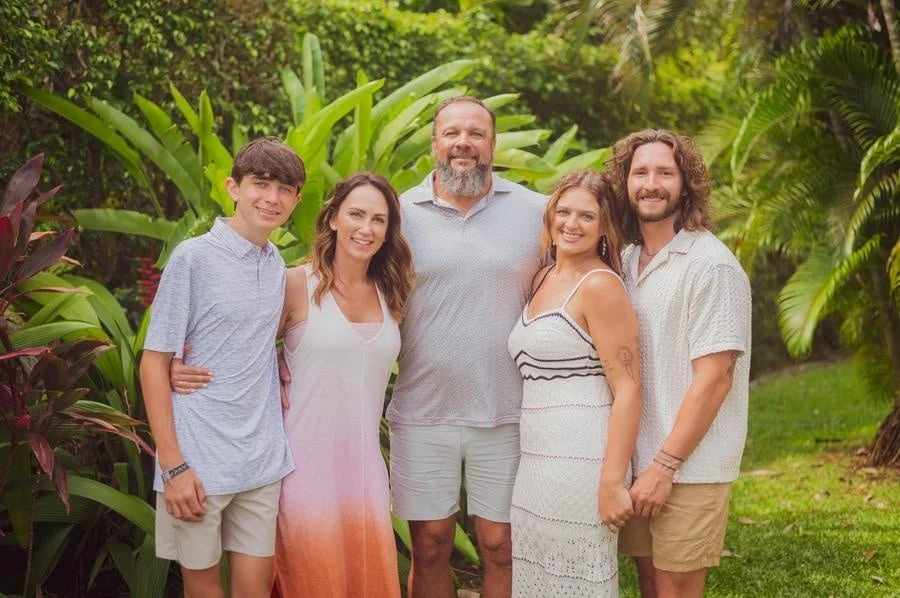 people and lifestyle photography -13 | Pacific Photography Family of five posing together in a tropical garden, smiling at the camera.