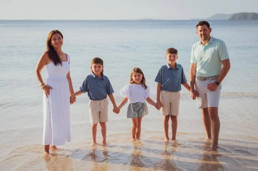 people and lifestyle photography -20 | Pacific Photography Family of five standing in shallow ocean water at the beach, holding hands and smiling.