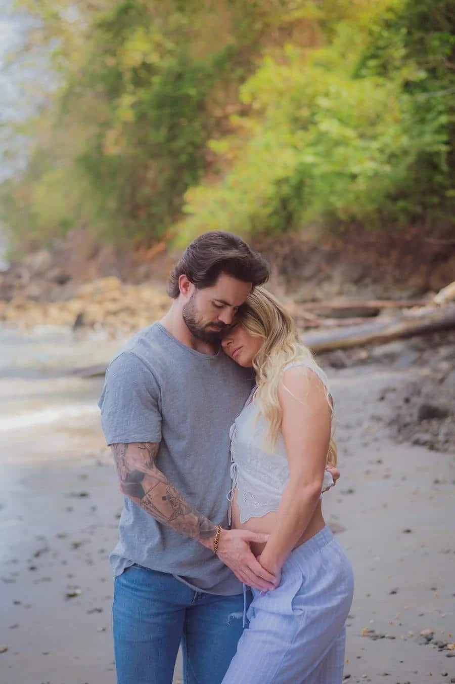 people and lifestyle photography -23 | Pacific Photography Couple hugging on a sandy beach, heads resting together in a tender moment.