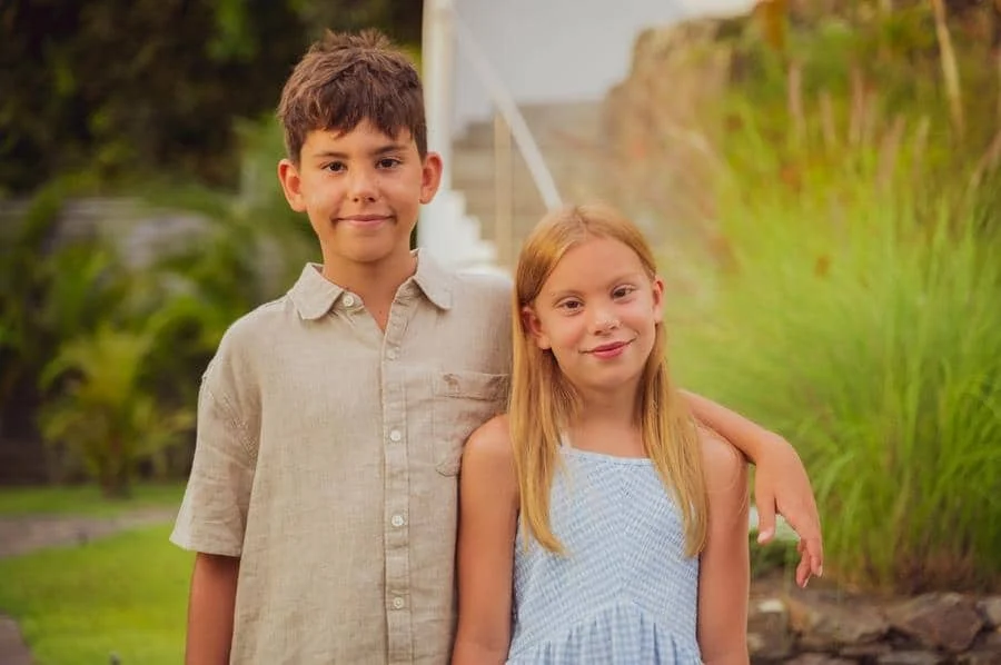 people and lifestyle photography -45 | Pacific Photography Two smiling children, a boy with his arm around a girl, posing together in a garden.