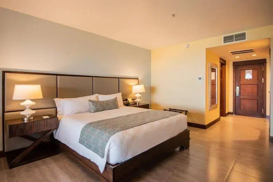 fotografia-para-propiedades-espacios-10 | Pacific Photography Habitación de hotel con una cama king, dos mesitas de noche e iluminación cálida.