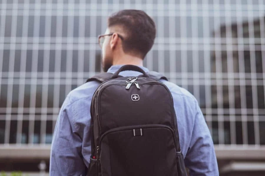 product photography costa rica -10 | Pacific Photography Man with a black backpack standing in front of a glass office building, seen from behind.