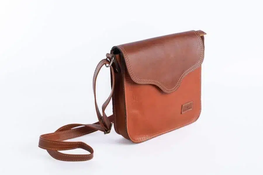 product photography costa rica -2 | Pacific Photography Brown leather crossbody bag with a curved stitched flap on a white background
