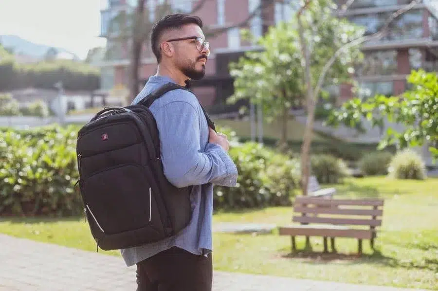 product photography costa rica -8 | Pacific Photography Man with a large black backpack standing outdoors in a park, wearing glasses and a blue shirt