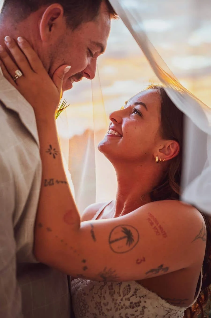 wedding ceremony photography costa rica-15 | Pacific Photography Bride and groom leaning in under a sheer veil, smiling at each other at sunset.