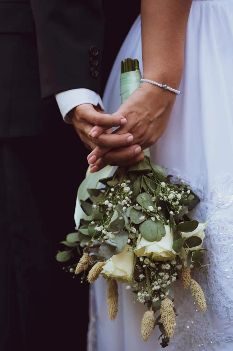 wedding ceremony photography costa rica-25 | Pacific Photography Close-up of a bride and groom holding a bouquet of white roses and greenery.