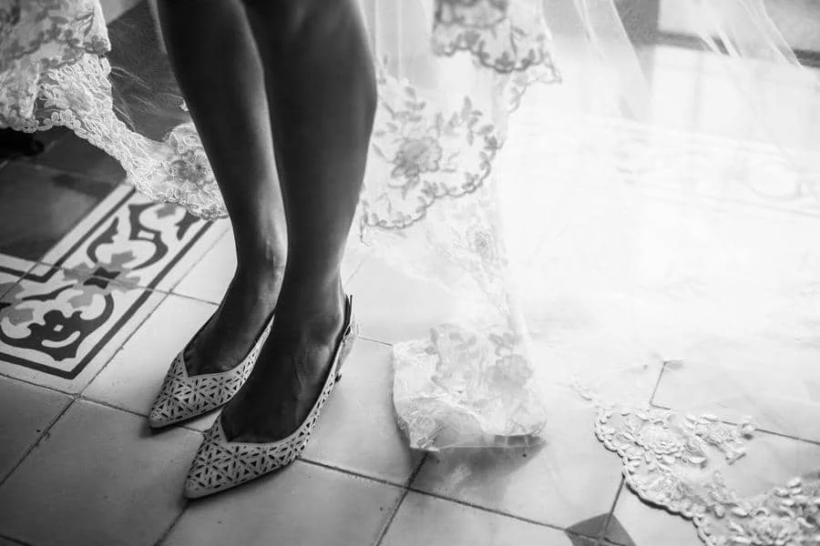 wedding prep photography costa rica-2 | Pacific Photography Bride's feet in pointed lace heels on tiled floor, with lace train trailing beside.