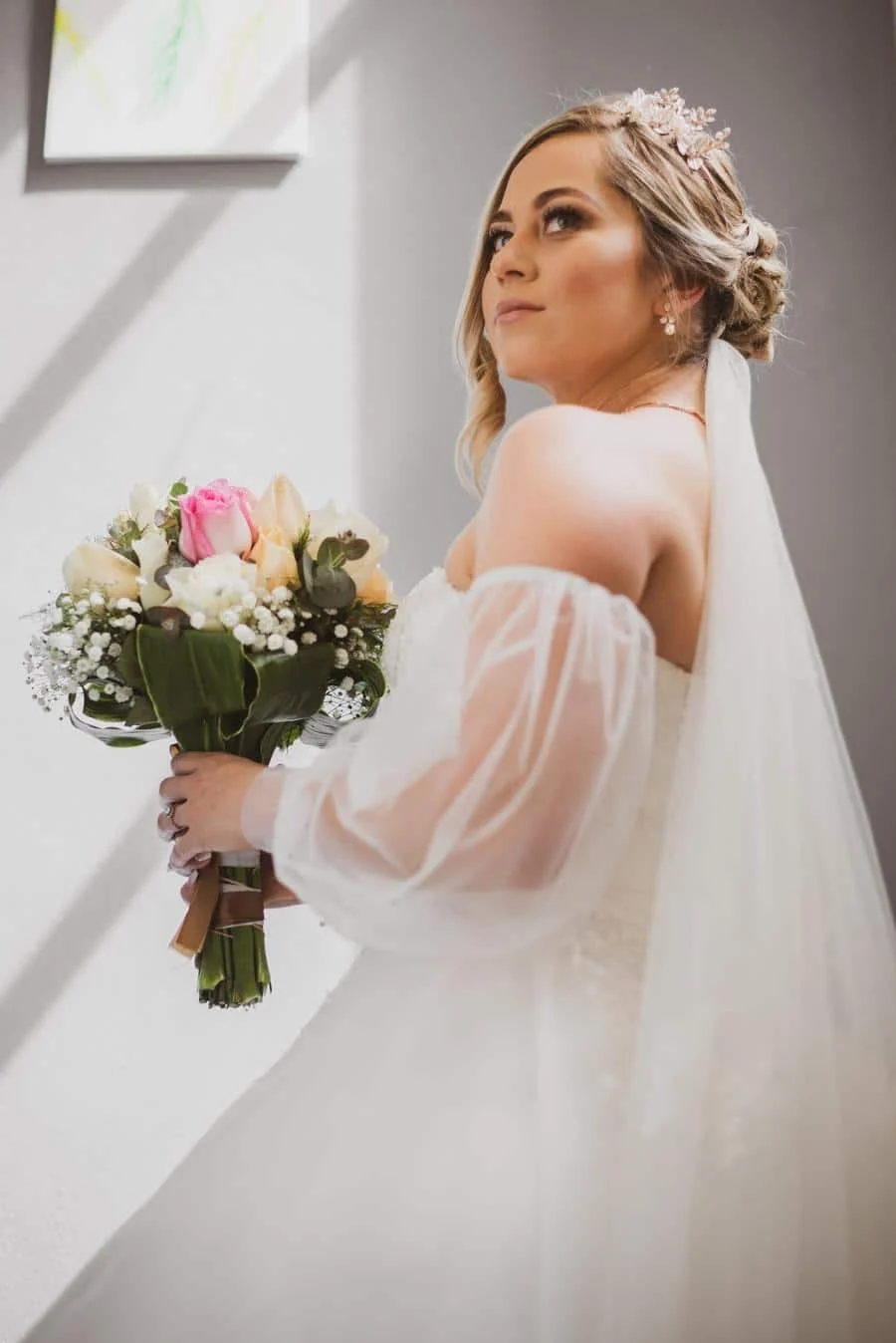 wedding prep photography costa rica-7 | Pacific Photography Bride in a white off-shoulder wedding dress with a veil, holding a pastel bouquet of pink roses, white blooms, and greenery hand‑to‑hand.